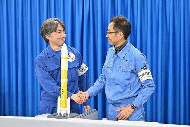 打ち上げ後、喜びを分かち合う、JAXAの岡田匡史プロジェクト・マネージャー（当時、右）と、三菱重工の新津真行プロジェクト・マネージャー（左）
